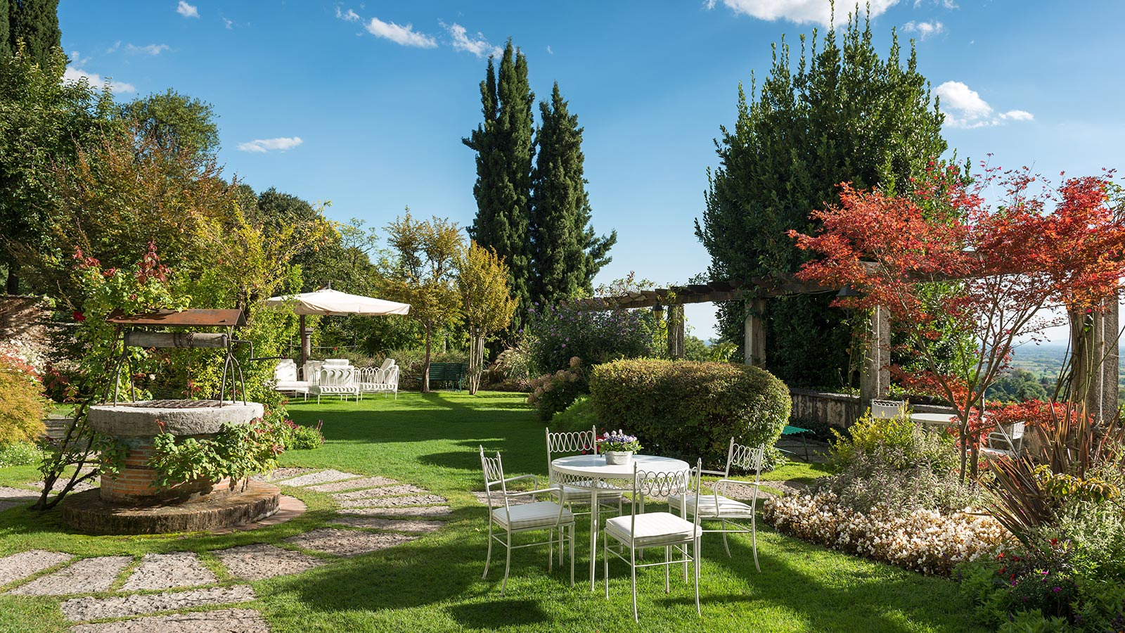 Le jardin verdoyant avec un ancien puits de la Villa Cipriani à Asolo