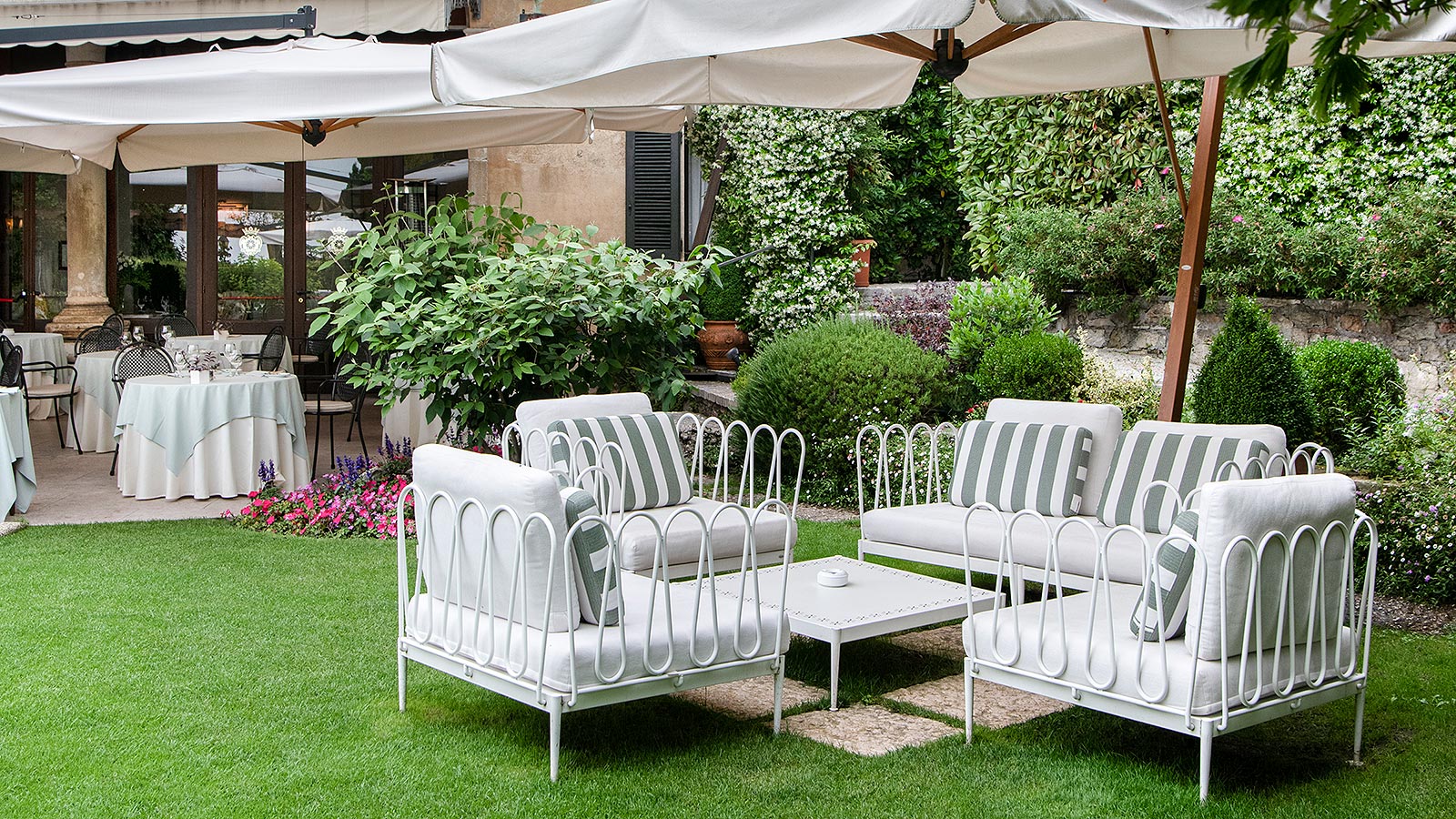 Détail de quelques tables et canapés dans le jardin de l'hôtel à Asolo