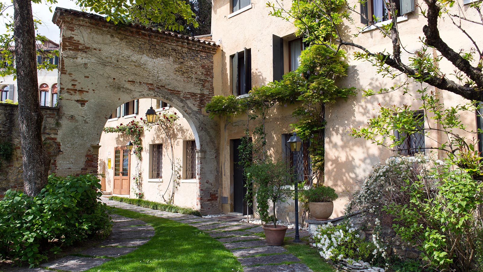 Une ancienne arche en pierre placée dans le jardin de l'hôtel à Asolo